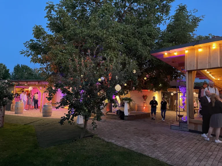Abendstimmung im Bruders Schopf Oberkirch mit stimmungsvoller Beleuchtung, DJ-Lichtshow und Gästen im Außenbereich.