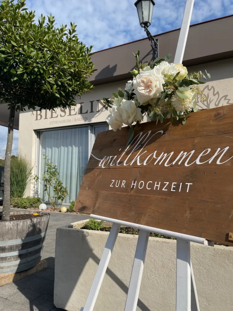 Willkommensschild zur Hochzeit am Eingang des Weinguts Bieselin in Ettenheim mit Blumenschmuck.